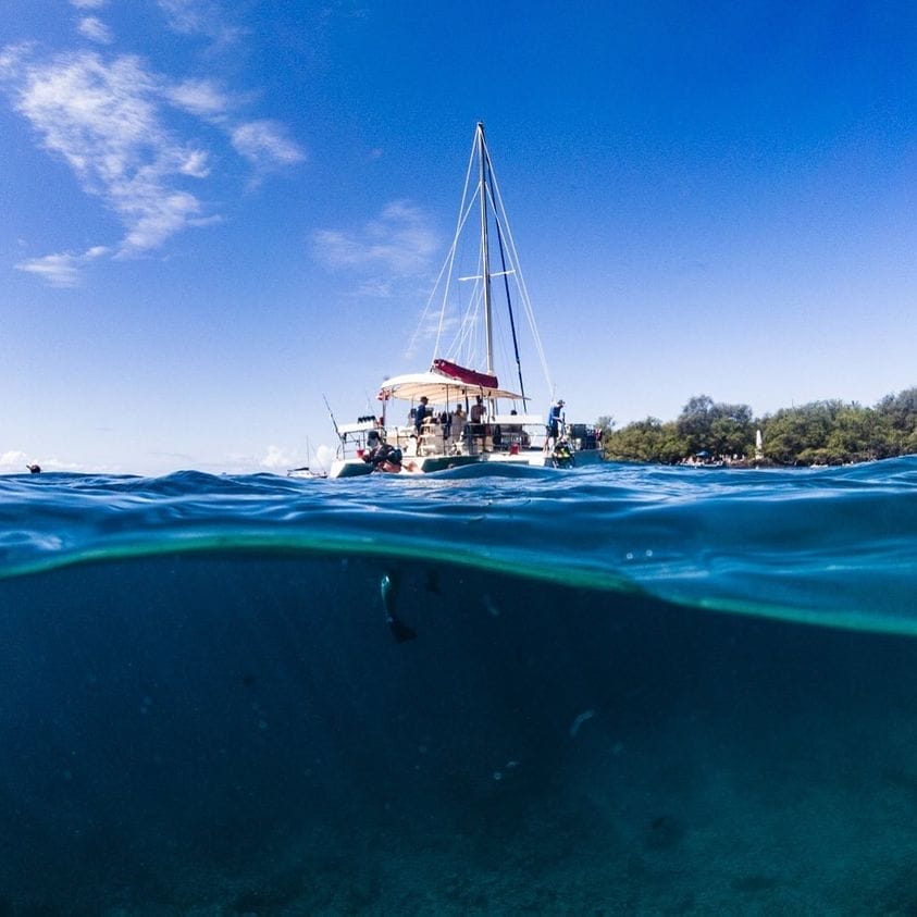 That feeling when you climb back on the boat after snorkeling Kealakekua Bay — the Captain Cook Monument behind you and a big shaka to cap it off!